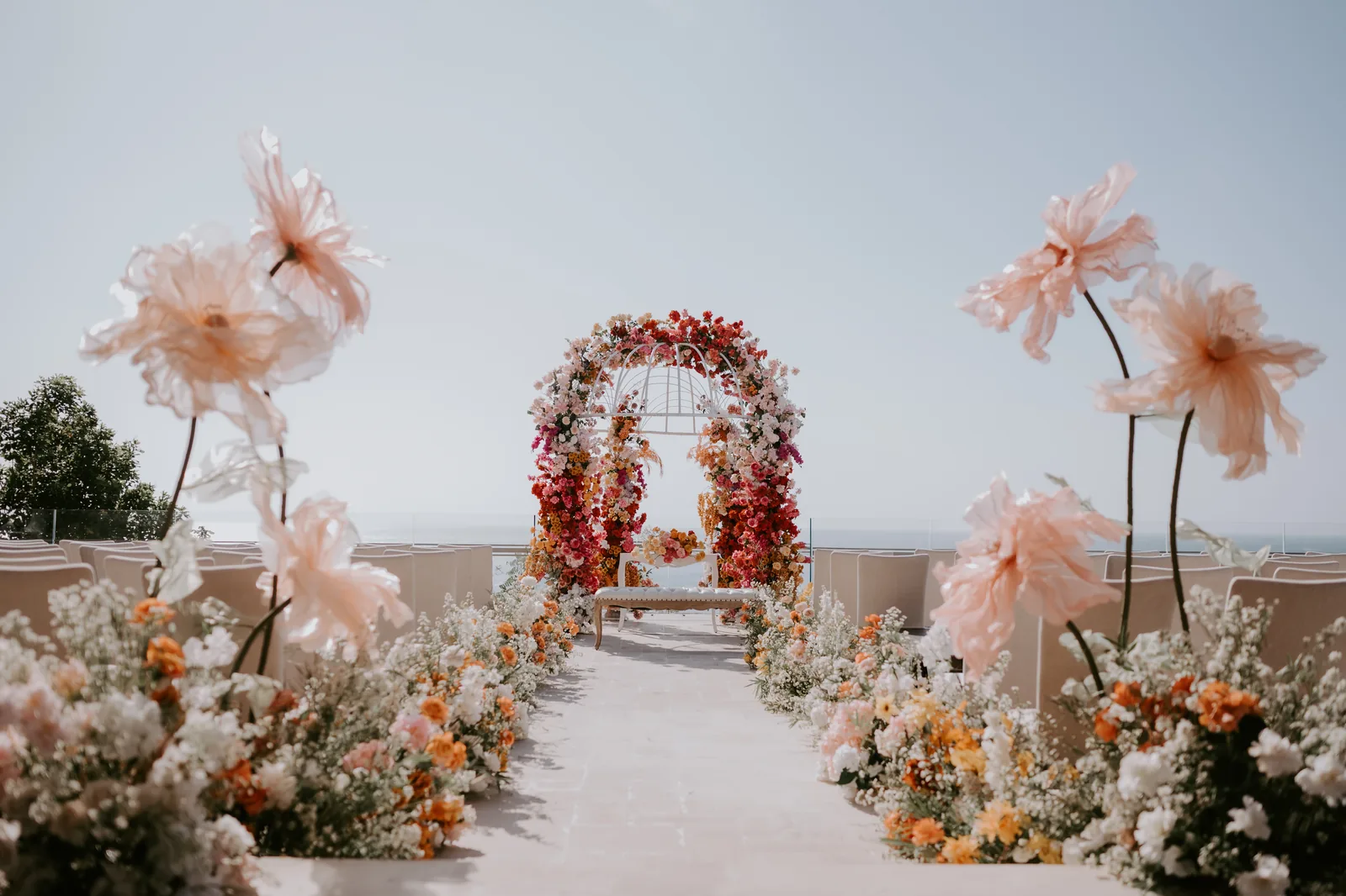 A floral ceremony arch set above the ocean at Jumeirah Bali