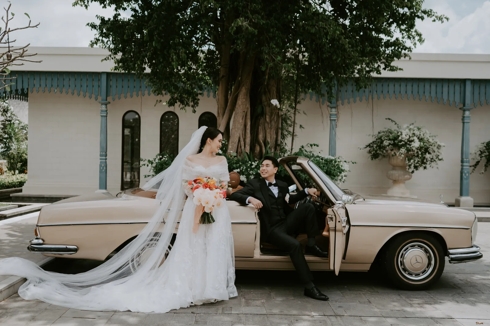 A couple with a vintage car in the grounds at Jumeirah Bali